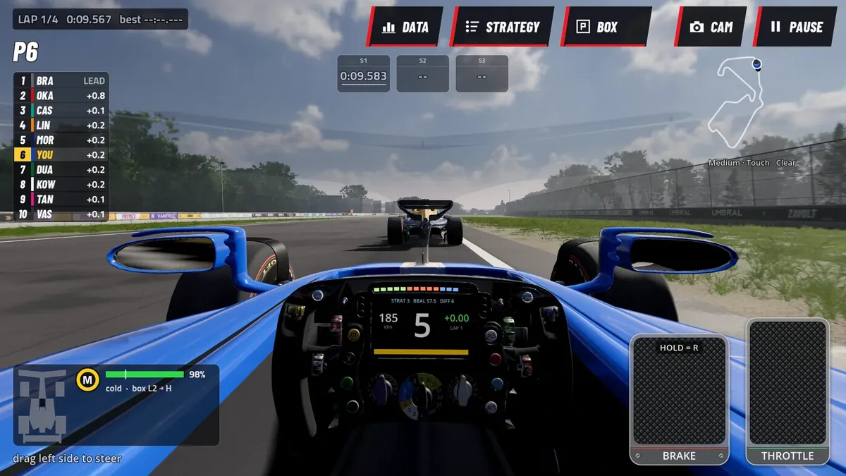 Cockpit camera: the steering wheel and its gear display, the blue nose of the car pointing down the track